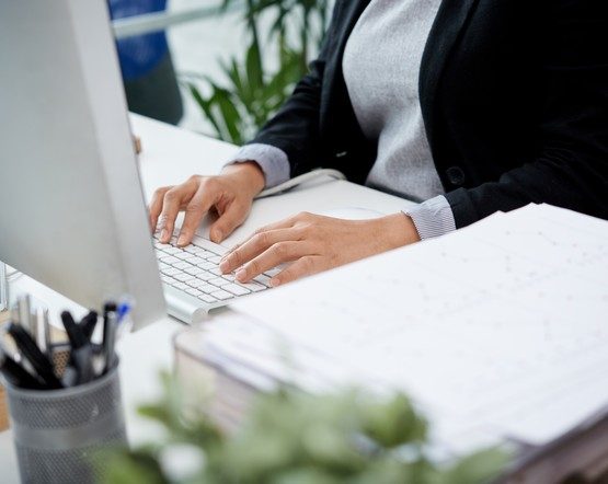 Hands of female manager on computer keyboard, selective focus